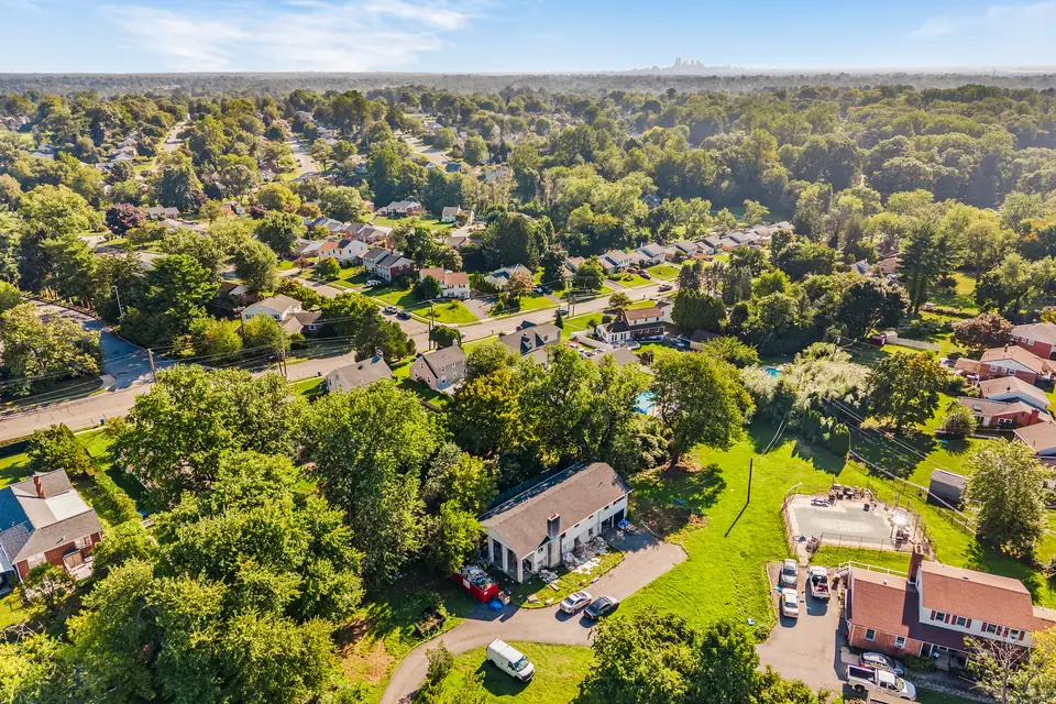 Aerial view over 641 W Sproul Road and the surrounding Springfield neighborhood, mature trees on every side.