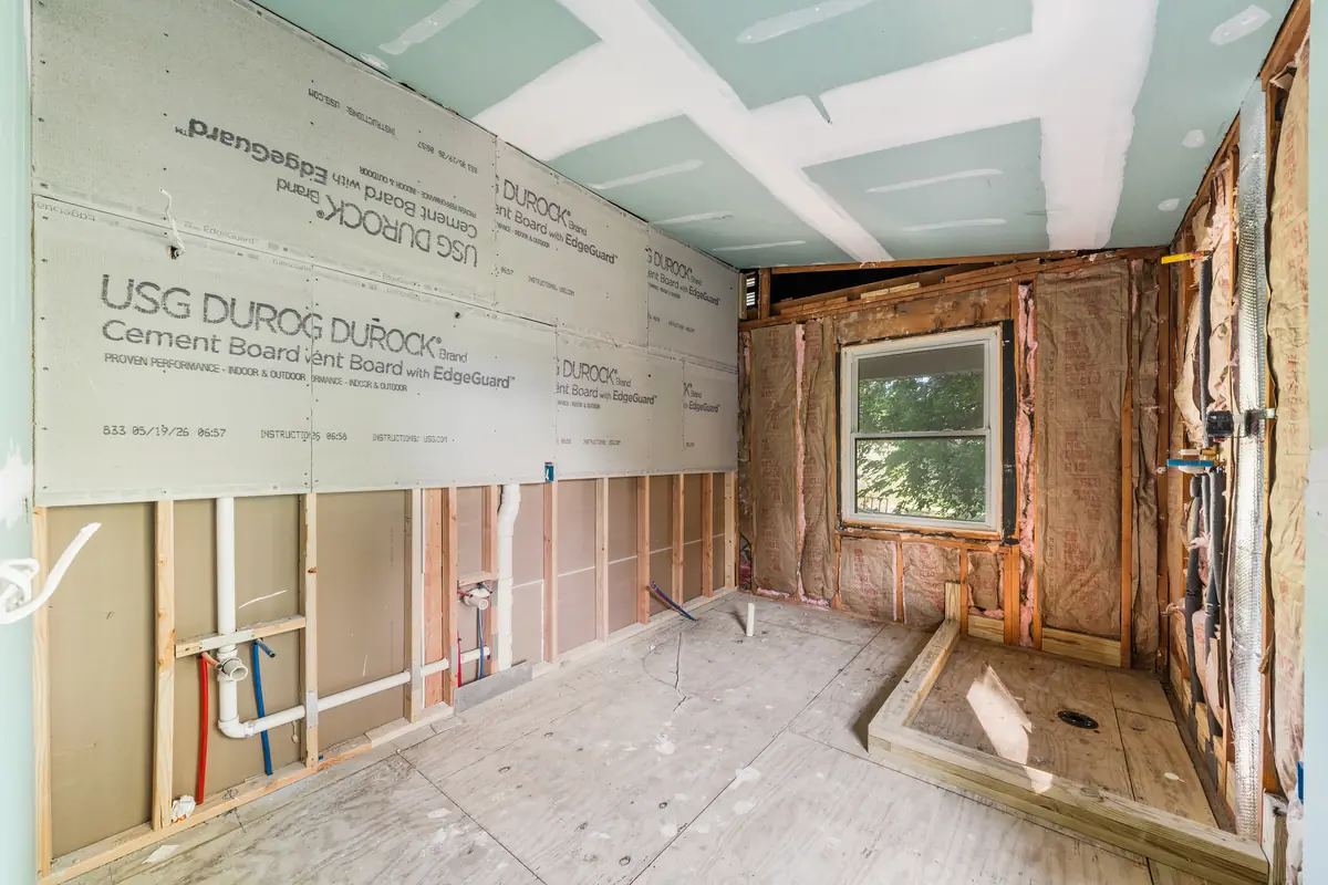 A bathroom opened to the framing with new insulation, cement backer board and new plumbing rough-in.