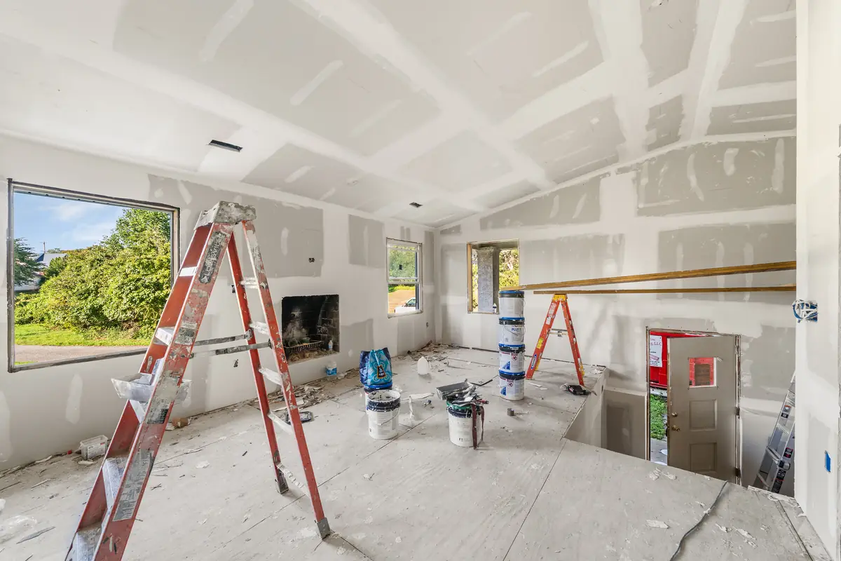 The great room with new drywall and a new window, before paint and flooring.