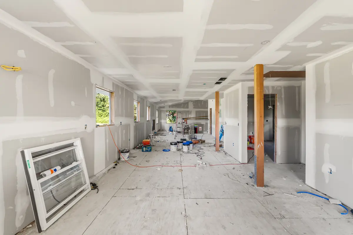 The open main level in drywall: kitchen, great room and sunroom on one long sightline.